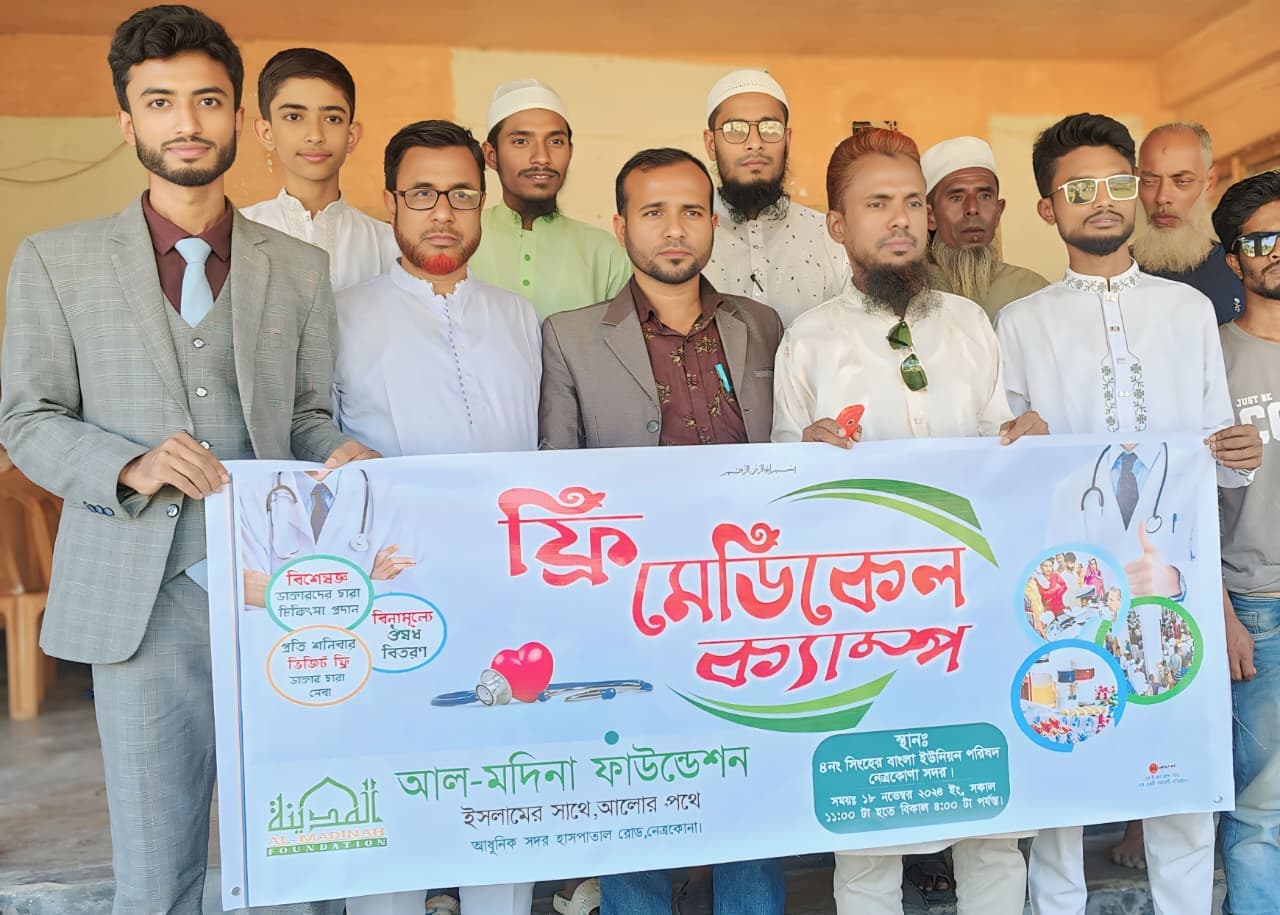 বিনামূল্যে মেডিকেল ক্যাম্পের ব্যানার হাতে একদল অংশগ্রহণকারী।
